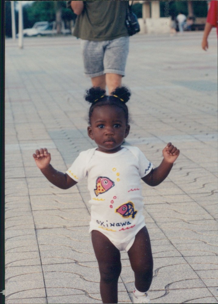 A young child in an Okinawa onesie walking outdoors