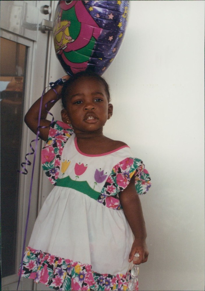 A young girl holding a large foil balloon