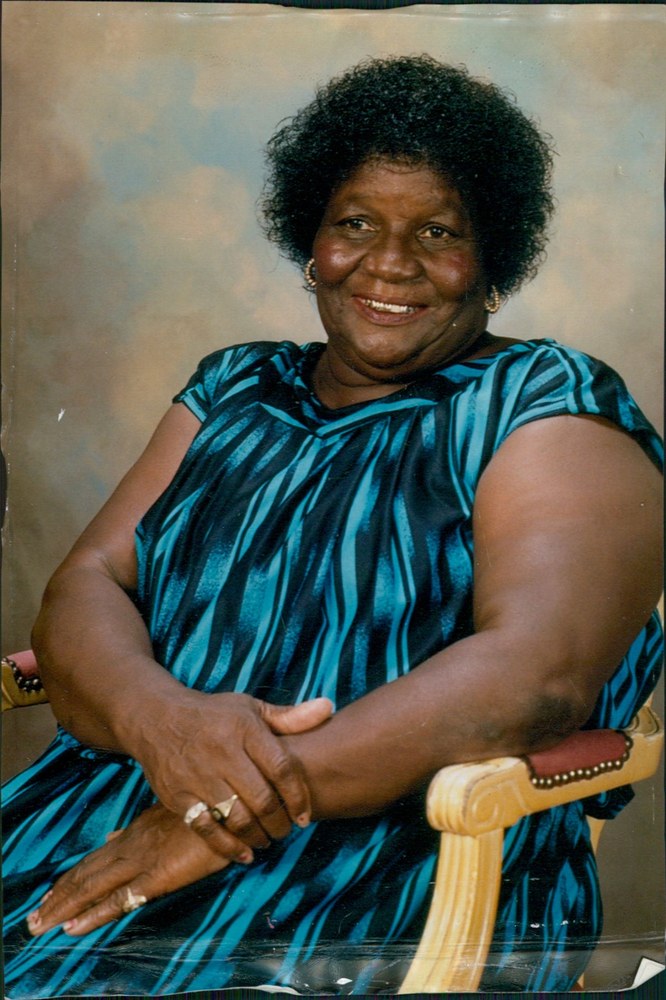 Portrait of Margaret McCoy, the Candy Lady, seated in a teal striped dress